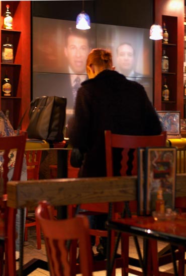 Woman in restaurant with large screen TV